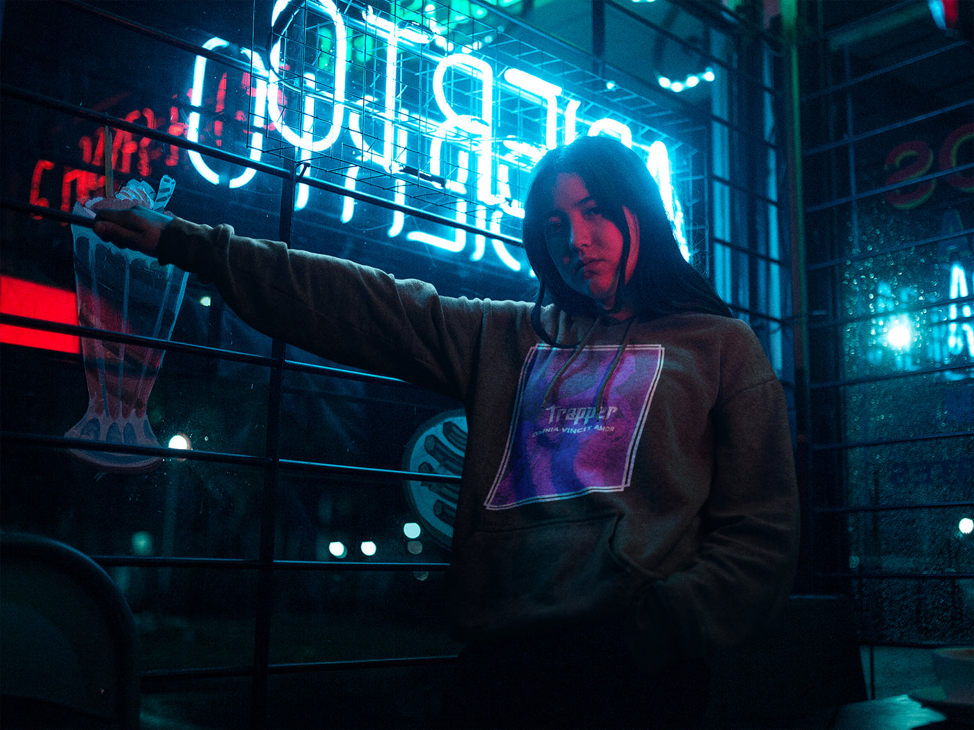 Chica con sudaderas trapper original urbana. La sudadera es negra y tiene una capucha. Sudadera con estampado casual y estilo trap.